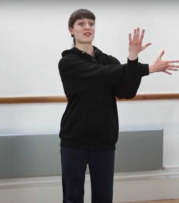 Person in a dance studio with the arms crossed over eachother at right angles.