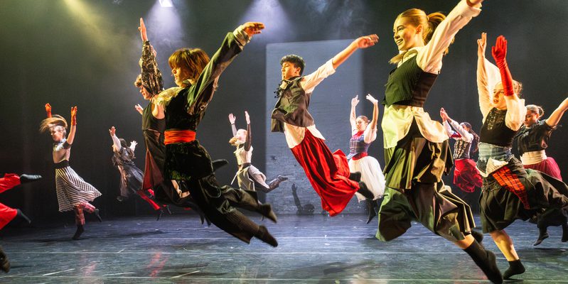 A group of young dancers leap into the air