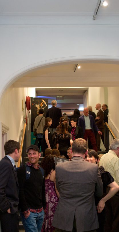Busy stairwell to The Place bar on the way into the theatre. Lots of people are standing and talking
