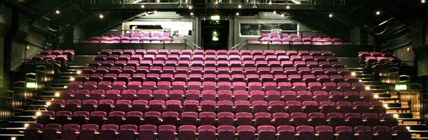 a photo of The Place theatre seats taken from the stage. The seats are purple and empty.