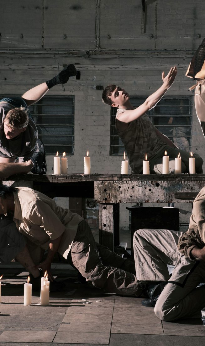 Six individuals positioned around a table surrounded by candles