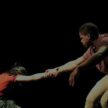 The performers are holding hands facing each other and leaning away, counter-balancing each other’s weights.