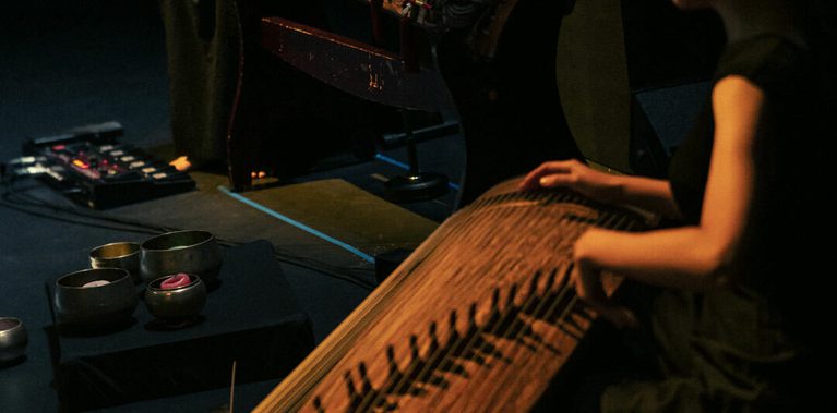 Two musicians dressed in black playing instruments.
